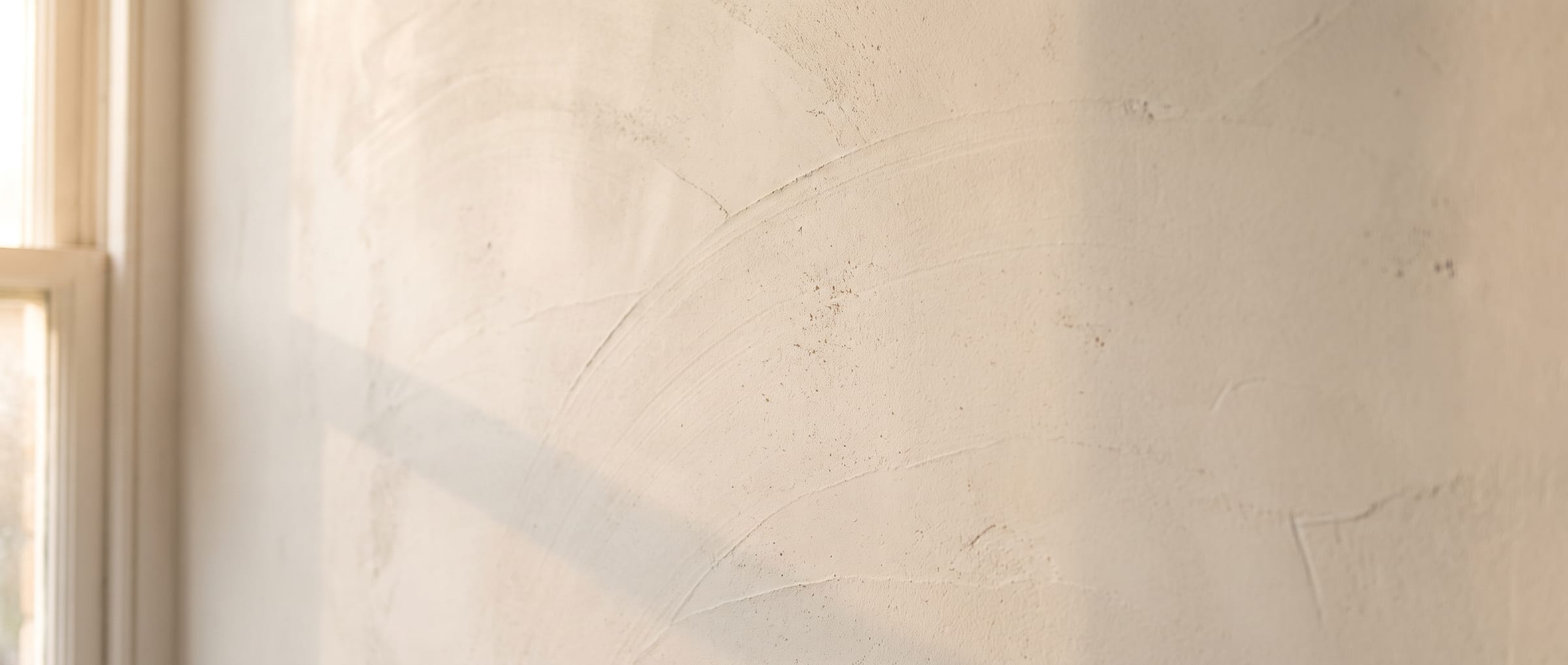 Freshly floated lime plaster wall in raking window light